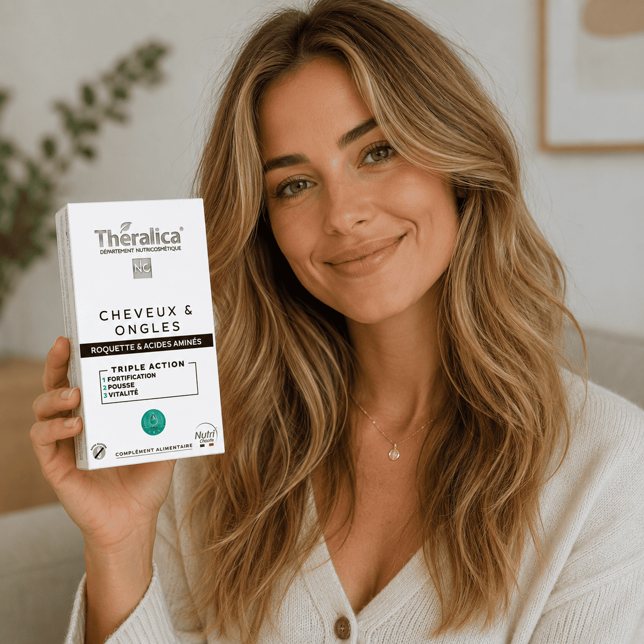 Femme blonde tenant le complément alimentaire Cheveux et Ongles Theralica